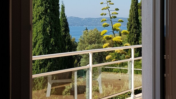 A balcony with a railing, overlooking a landscaped garden and a distant view of the sea. - Near beach villa 10p with pool le lavandou (Le Lavandou)