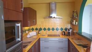 A kitchen with wooden cabinets, a stainless steel refrigerator, a built-in oven, a gas stove, a microwave, a toaster, a coffee maker, and a sink. - Near beach villa 10p with pool le lavandou (Le Lavandou)