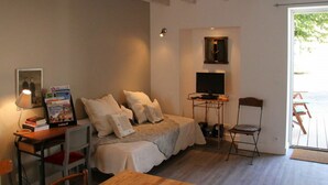 Ein Schlafzimmer mit einem Bett, einem Nachttisch, einer Lampe und einem Fernseher.