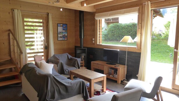 A cozy living room with a sofa, chairs, a TV, and a fireplace. - Chalet for 8 pers. with large terrace and parking (Les Contamines-Montjoie)