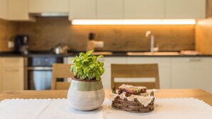 Una cocina con una planta en maceta, una cesta tejida y una mesa con un mantel individual.