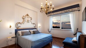 Une chambre à coucher avec un lit, un banc, un lustre et une fenêtre donnant sur un beau paysage.