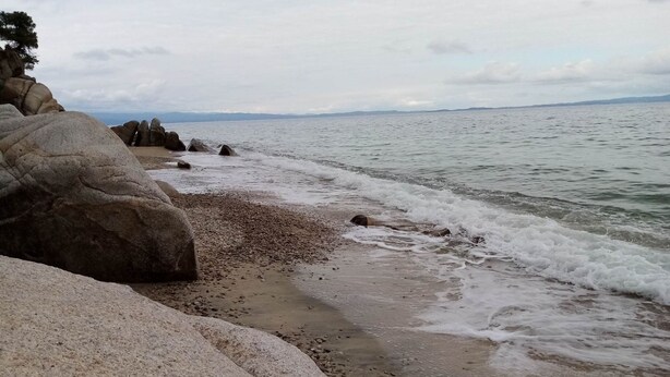 A rocky beach with waves gently lapping at the shore. - Petrino1880 Sea-vacation Apartment in Chalkidiki (Sithonia)