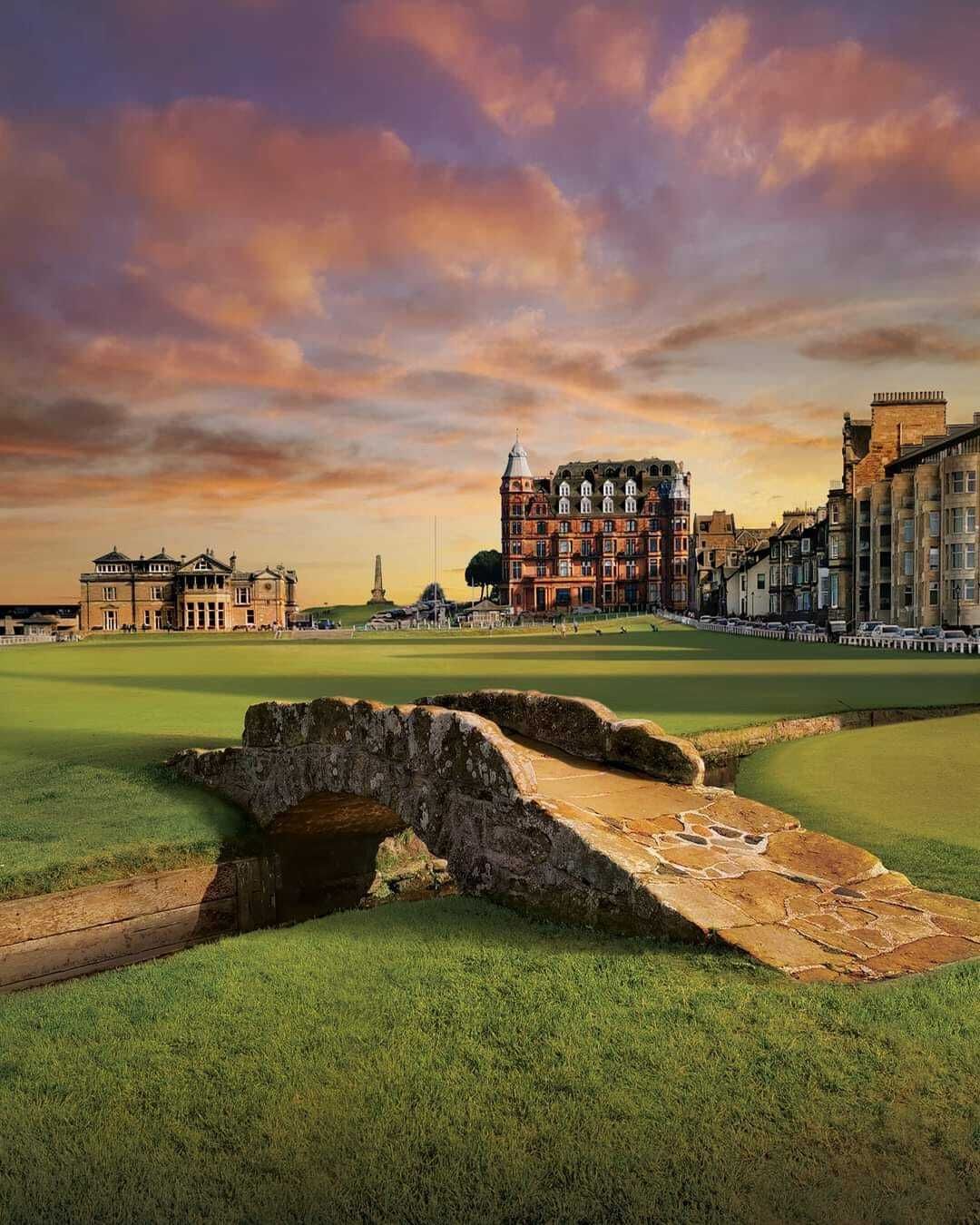 A golf course with a historic building and a stone bridge.