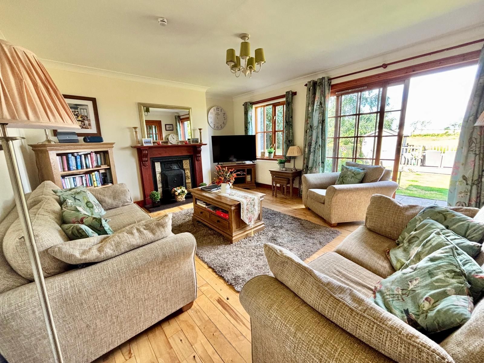 A living room with a fireplace, sofas, a coffee table, and a television.