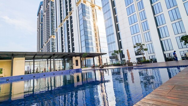 A modern hotel with a swimming pool, high-rise buildings, and a covered walkway. - Lovina at Pollux Meisterstadt (Batam)