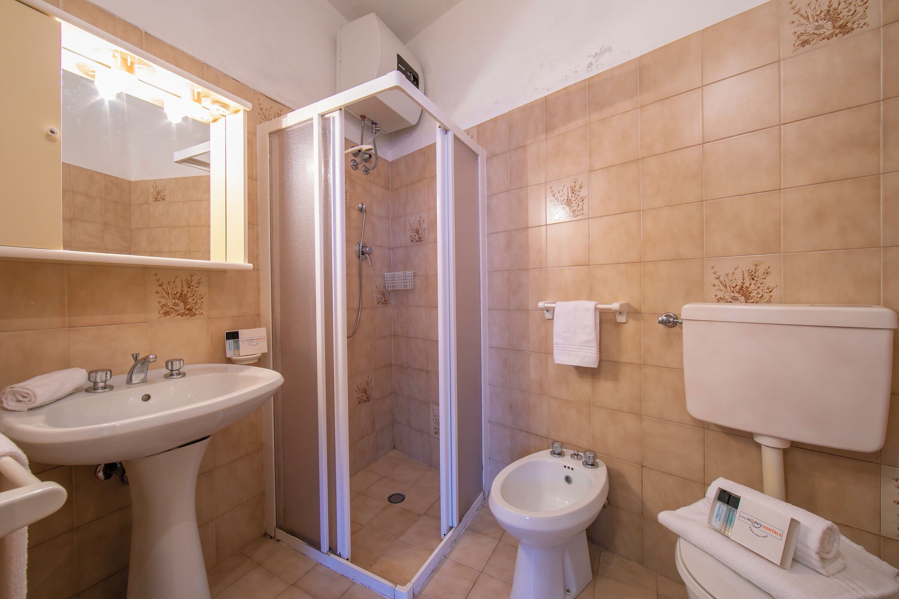Une salle de bain équipée d’un lavabo, d’un bidet, de toilettes et d’une douche.