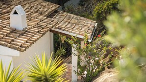 A building with a tiled roof, a chimney, and surrounding greenery. - Villa INFINIDAD by Abahana Villas (Moraira)