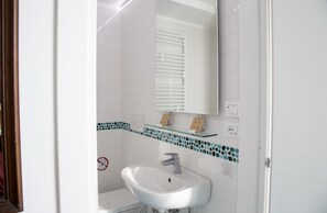 A bathroom with a white sink, a mirror, and a tiled backsplash. - 2 Bed Flat - Sleeps 4 - Parking - Wifi (Ravello)