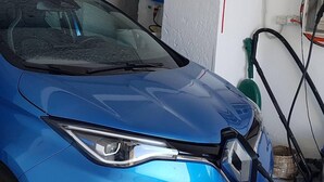 A blue car in a garage with visible hoses and a power outlet on the wall. - 2 Bed Flat - Sleeps 4 - Parking - Wifi (Ravello)