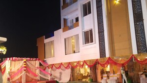 A multi-story building with a stage area decorated with drapes and a green carpeted floor.