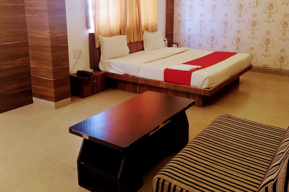 Ein Hotelzimmer mit Bett, einer Couch, einem Couchtisch und einem Deckenventilator.