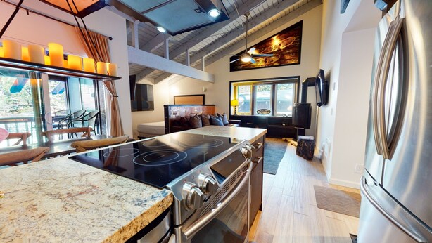 A modern kitchen with a central island, built-in oven, and a large stove. - Mammoth Estates Studio Condos - 2 Blocks from The Village Gondola Station by RedAwning (Mammoth Lakes)
