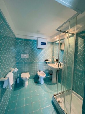 A bathroom with a glass shower enclosure, a toilet, a bidet, and a sink. - Studio, by the sea, sleeps 3 (Mughetto) (Anzio)