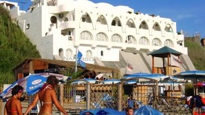 A white building with multiple balconies and arched windows. - Studio apartment, beachfront, floor 2, private descent to the beach (Narcissus) (Anzio)