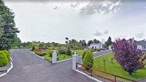 Une rue résidentielle bordée de maisons, avec une pelouse bien entretenue et une allée gravillonnée.