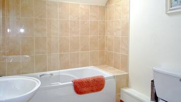 A bathroom with a bathtub, a sink, and a toilet.