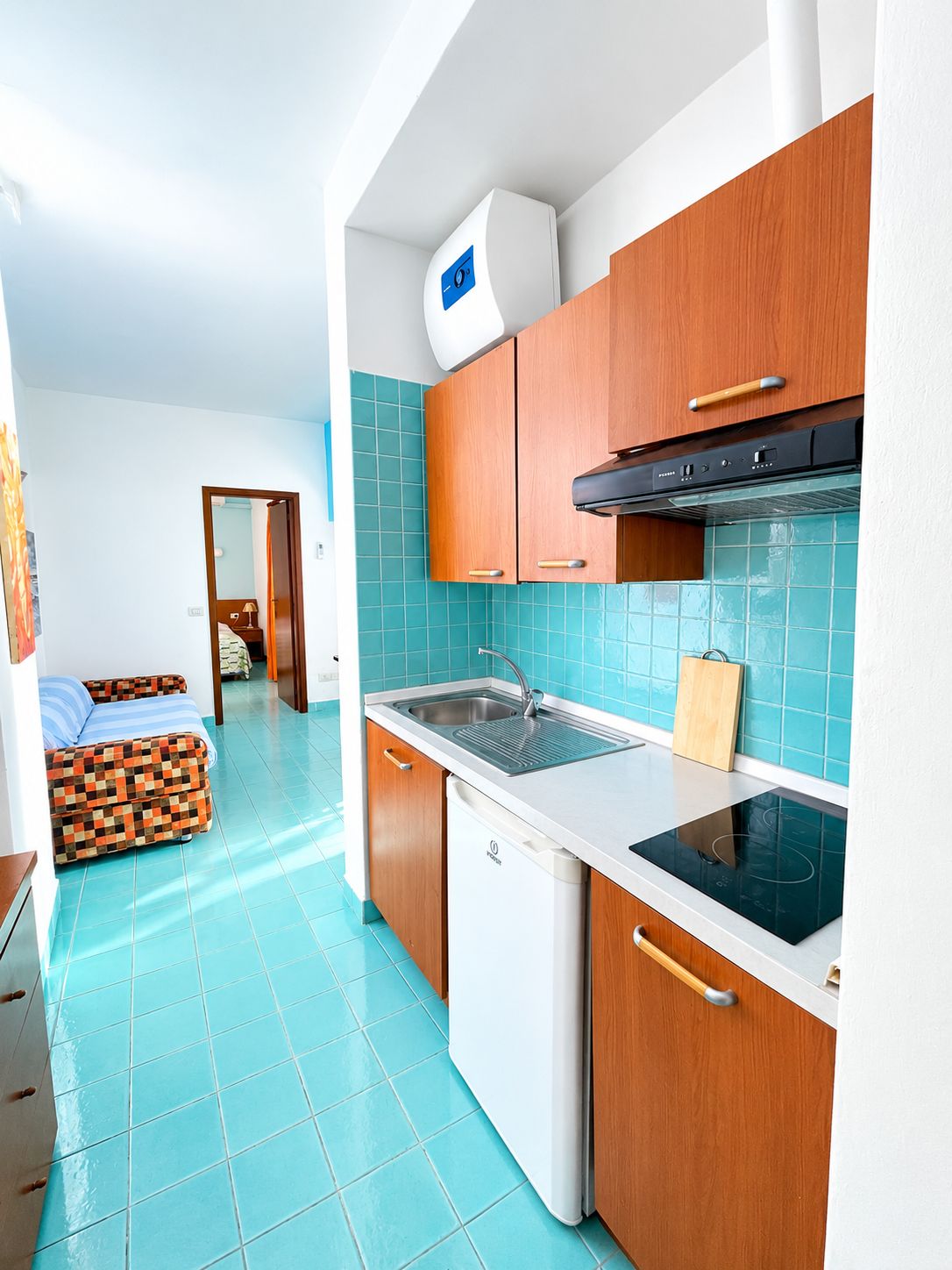 A compact kitchen with a dishwasher, stove, and a sink.