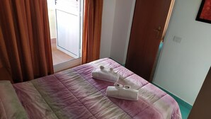 Una habitación de hotel con una cama, una puerta y una ventana.