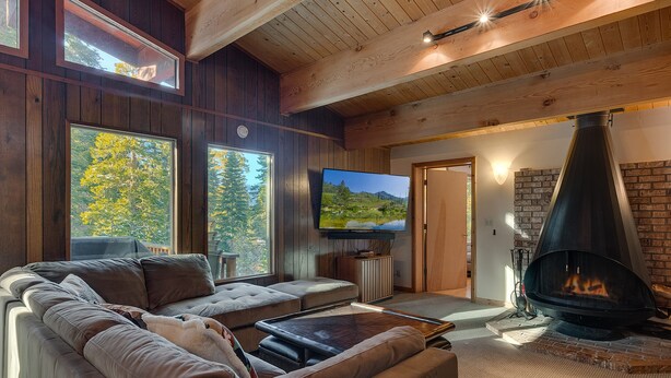 A cozy living room with a large sofa, a flat-screen TV, and a fireplace. - Chamberlands Cabin: 5  BR, 3  BA House in Tahoma, Sleeps 10 (Tahoma)