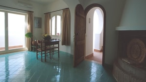 A spacious room with a dining area, a large window with curtains, and a view of the outside. - Two-room apartment, terrace, sea front, floor 1 (Mimosa) (Anzio)