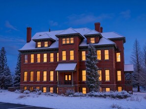 A large, multi-story brick building with multiple windows and a snow-covered landscape. - Papa's Place — Historic 1BR Brick Unit, Walk to Main St Leadville (Leadville)