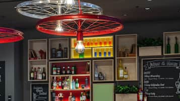 A bar area with wooden furniture, shelves with bottles, and a chalkboard menu.