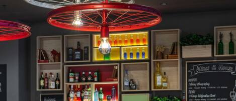 A bar area with wooden furniture, shelves with bottles, and a chalkboard menu.