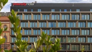 A modern Intercity Hotel building with a symmetrical facade, multiple windows, and a clear sky. - IntercityHotel Budapest (Budapest)