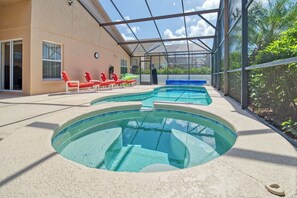 Ein Poolbereich mit mehreren Schwimmbecken, Liegestühlen und einer überdachten Terrasse.