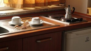 A kitchen with a coffee maker, two cups, and decorative items on a tray. - Studio apartment, sea front, terrace, floor 1 (Poppy) (Anzio)