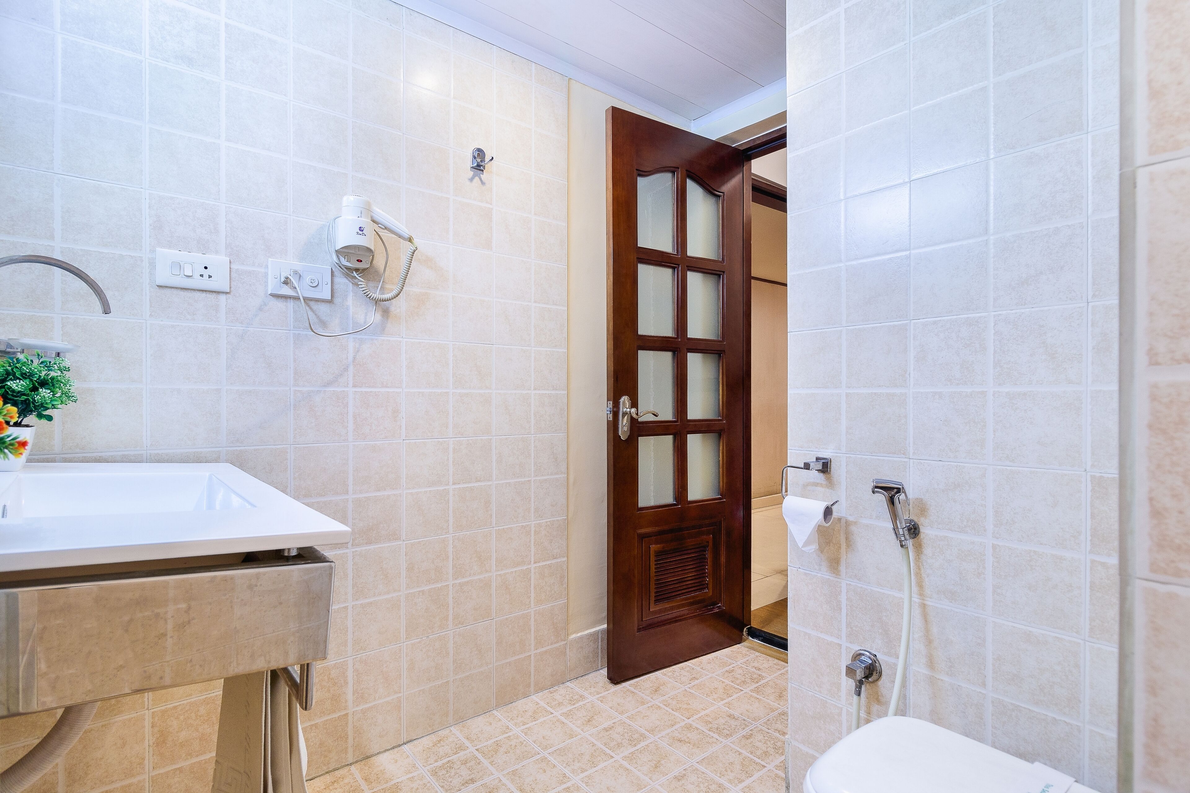 A bathroom with a sink, a hairdryer, and a shower.