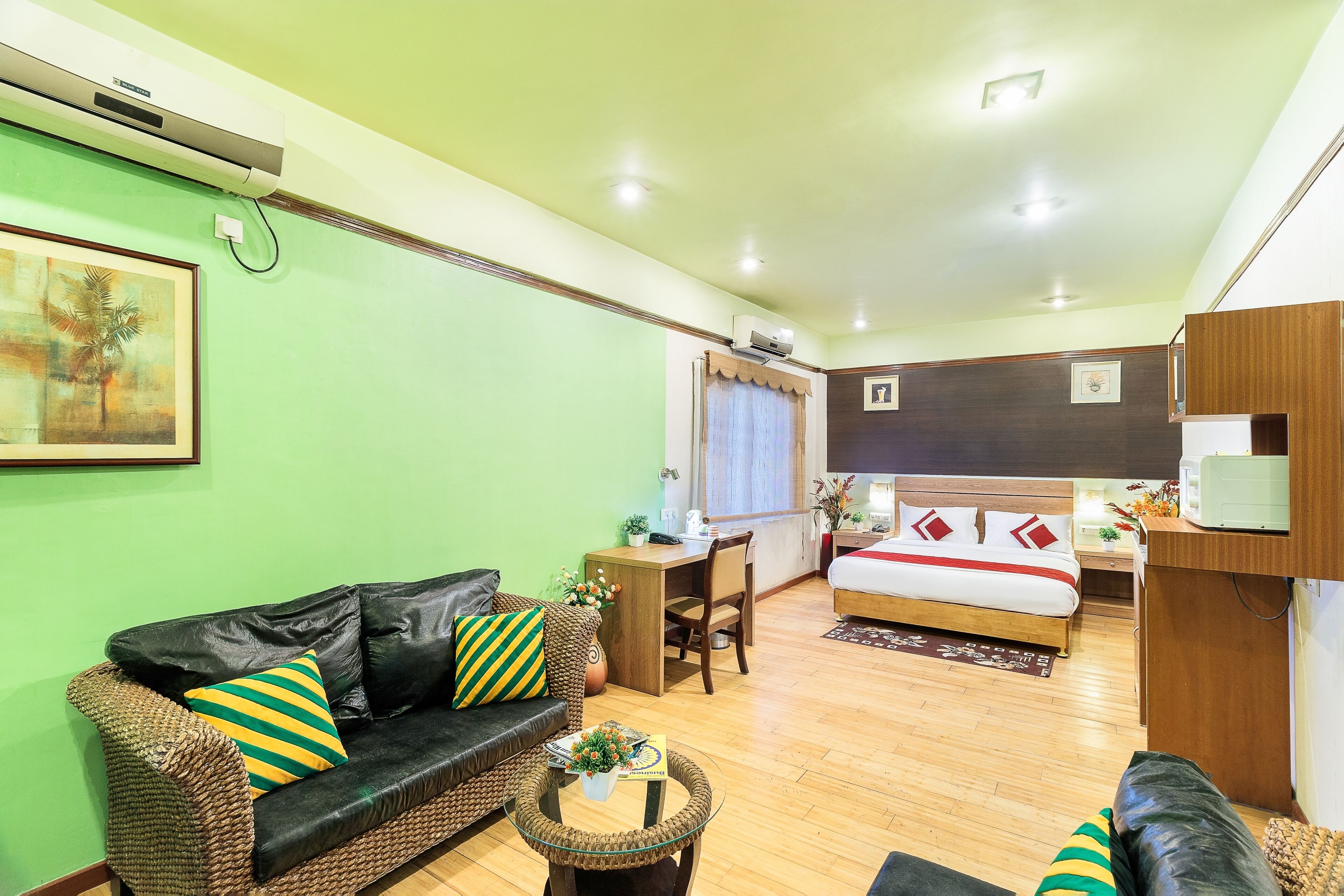 A compact living space with a sofa, a small table, a bed, and a desk.