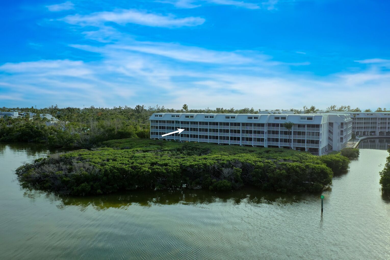 A modern building with a grid-like facade, situated on an island surrounded by water.
