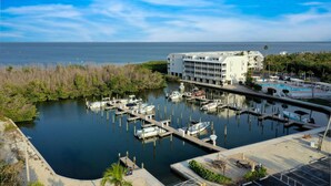 A marina with boats docked, a hotel with a pool, and a clear view of the ocean. - Bayside Villa 5236: Bayfront Views! (Captiva)