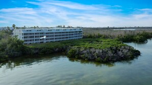 A modern building with a flat roof, surrounded by water and dense vegetation. - Bayside Villa 5236: Bayfront Views! (Captiva)