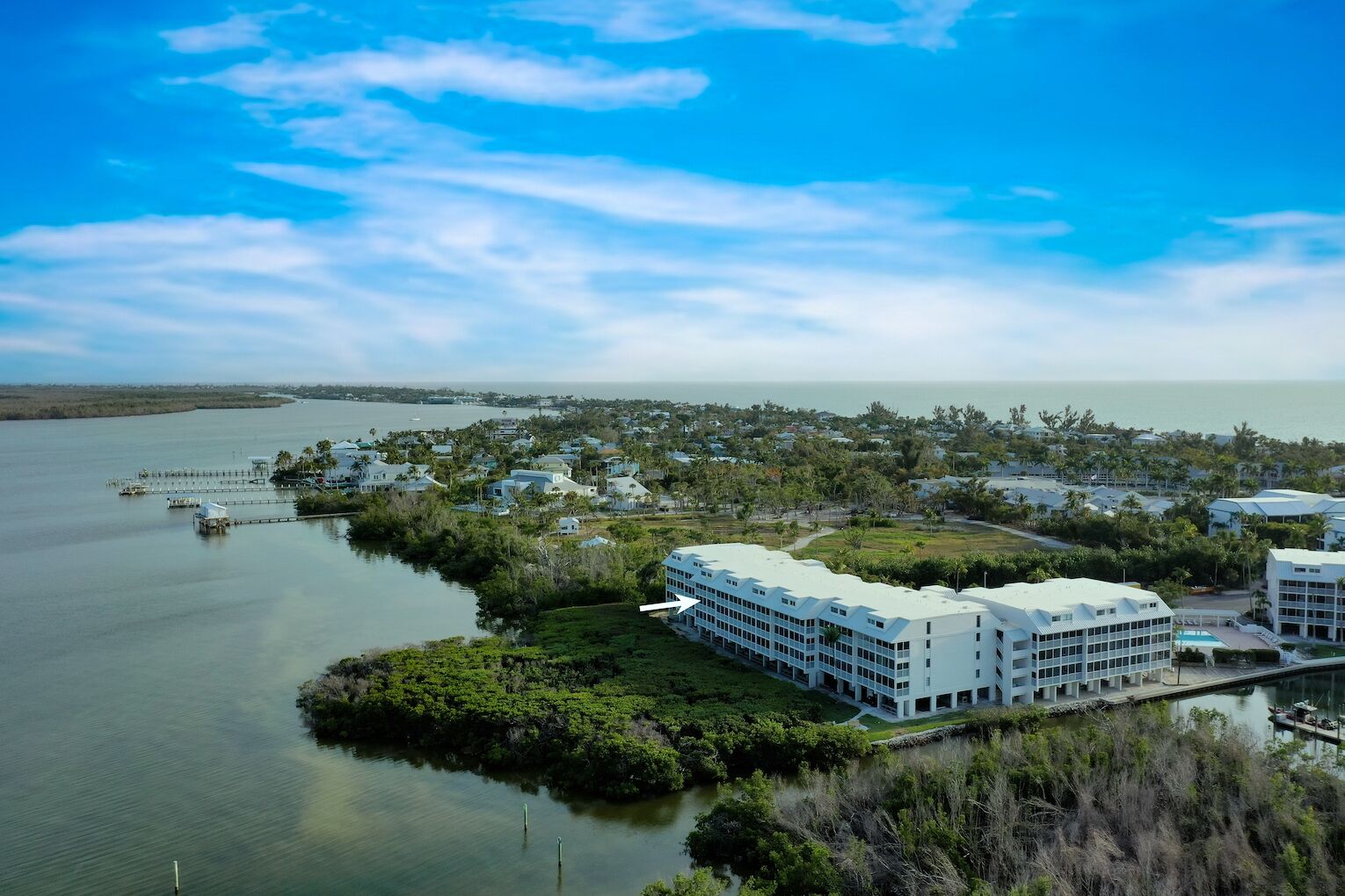 Een kusthotel met meerdere gebouwen, een jachthaven en een groot wateroppervlak.