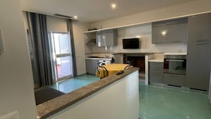 Una cocina moderna con una isla central, electrodomésticos integrados y un amplio ventanal.