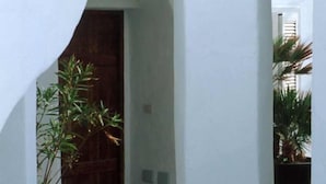 A narrow corridor with white walls and a wooden door at the end. - Double room, Terrace, No kitchen, Ground floor (Gardenia) (Anzio)