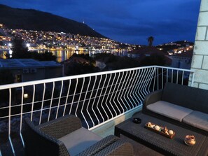 Un balcon donnant sur une vue panoramique de la ville au crépuscule.