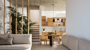 Un salon moderne comprenant un canapé, un coin repas et une cuisine.