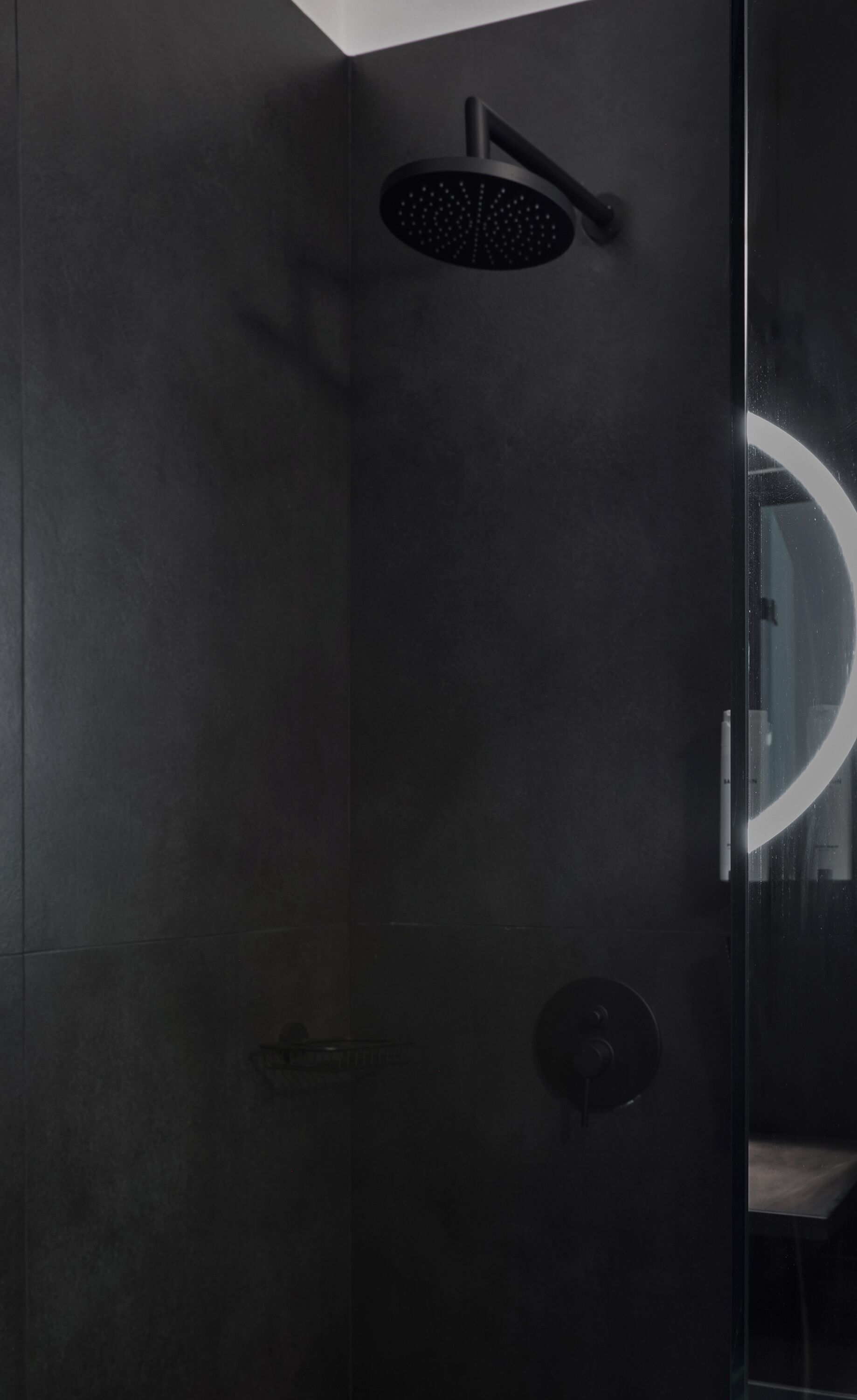 Une douche moderne dotée d’un pommeau circulaire et d’un panneau de commande.