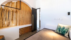Interior moderno com parede de madeira, porta preta, luminária pendente e almofada com tema de cactos.