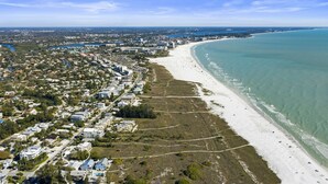 An aerial view of a coastal city with a long beach, dense residential area, and a river running through the city. - Beach Access, Walk to village, Sunsets included (Sarasota)