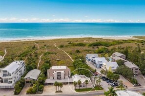 Vista aérea de una zona costera con edificios, una playa y una carretera.