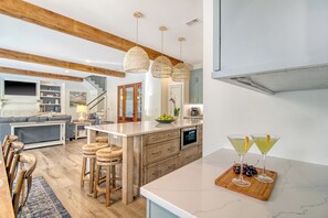 Enjoy meals in the kitchen with an oven, microwave, and sink, and dine at the wooden table with bar stools.