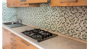 A kitchen with a gas stove, a sink, and wooden cabinets. - RS315 - Marcelli, two-room apartment in a seafront residence (Marcelli)