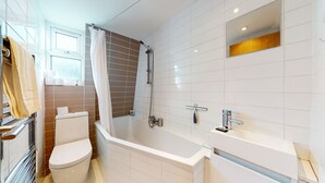 Un baño moderno con bañera, inodoro y lavabo.
