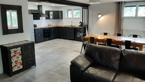 Eine moderne Küche mit schwarzen Schränken, einem Holztisch und einer Ledersofa.