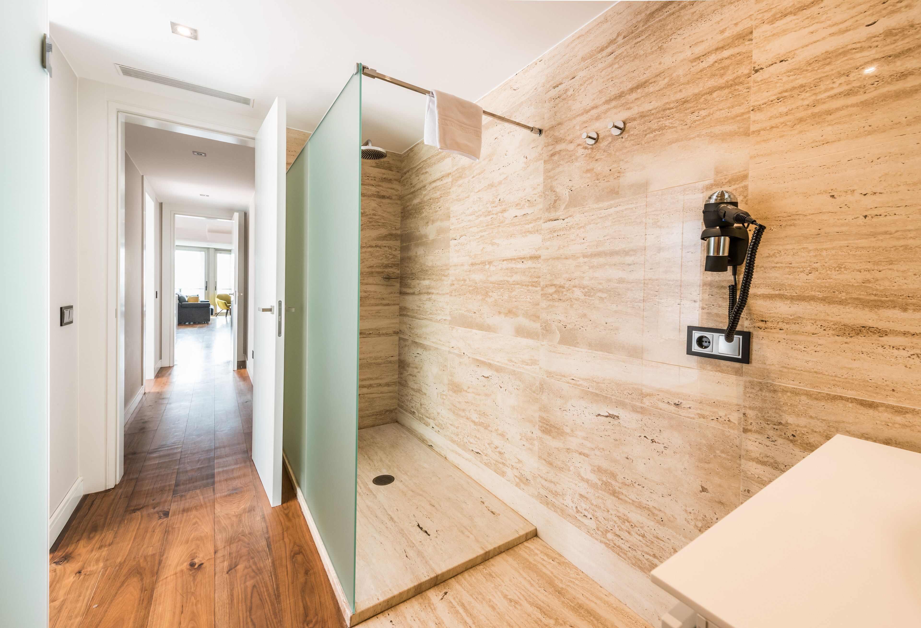 A modern bathroom with a shower, a toilet, and a sink.